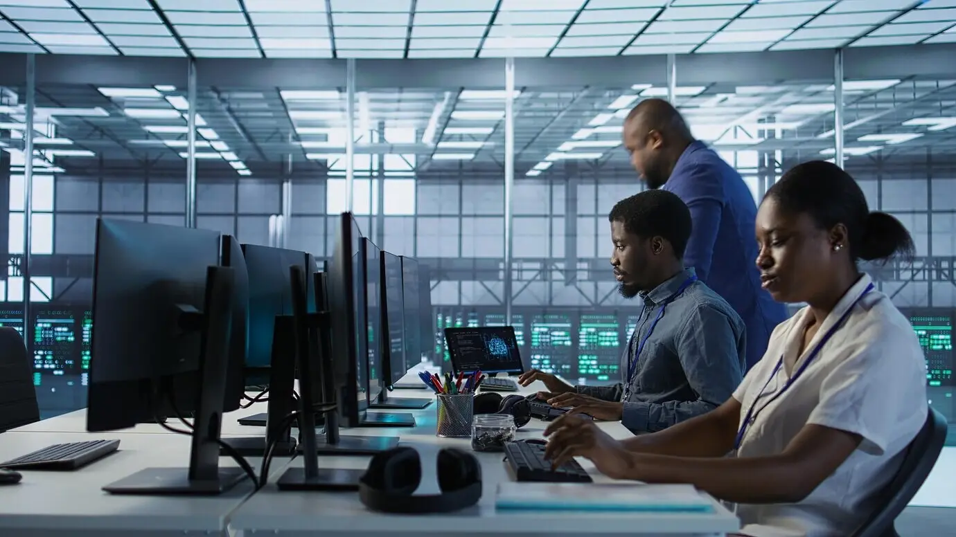 Сотрудник входит в центр обработки данных, приступая к рабочей смене по мониторингу производительности.